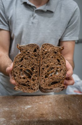 Boulanger tenant un pain coupé en deux
